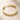 ENVYONE 18K Gold-Plated stainless steel bracelet with sculptural interlocking links on a beige stone surface.