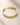ENVYONE 18K Gold-Plated stainless steel bracelet with sculptural interlocking links on a beige stone surface.