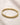 Closeup of an ENVYONE 18K Gold-Plated stainless steel bangle featuring a curved geometric design.