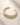ENVYONE 18k Gold-Plated gold cuff bracelet with rounded open ends photographed on a light beige natural stone surface.