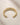 Close-up of ENVYONE 18K Gold-Plated stainless steel cuff bracelet on textured beige natural stone.