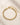 Closeup of an 18K Gold-Plated stainless steel mesh bracelet with an adjustable closure featured on beige stone surface.