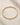 ENVYONE 18K Gold PVD-plated bangle bracelet with spaced zircon stones displayed on natural stone.