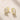 ENVYONE 18K Gold Plated huggie hoop earrings featuring baguette-cut and round zircon stones, displayed on a light beige stone surface.