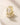 Pair of ENVYONE 18K Gold Plated hoop earrings featuring rows of baguette and round zircon stones on a textured stone background.