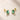 18K Gold Plated stud earrings with Emerald Cut Green Zircon in a four prong setting, displayed on a light beige stone surface.