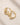 Pair of ENVYONE 18K Gold Plated sculptural hoop earrings with a smooth polished finish, displayed on a light beige stone surface.