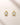 ENVYONE 18K Gold Plated 925 sterling silver stud earrings with brilliant round zircon stones in polished bezel settings, displayed on a light beige stone surface.