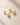 ENVYONE 18K Gold-Plated 925 sterling silver stud earrings featuring sparkling round cut zircon stones in sleek bezel settings, photographed on a textured light beige stone surface