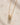 Closeup of ENVYONE 18K Gold-Plated necklace featuring a small sculptural ribbed pendant on a fine gold chain.