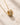 Closeup ENVYONE 18K Gold-Plated pendant necklace with a polished ridged design and delicate chain, displayed on textured natural stone.