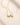 Closeup of an ENVYONE 18K Gold Plated 925 Sterling Silver zircon necklace displayed on textured beige stone.