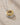 Close-up view of ENVYONE two-tone pendant necklace featuring a polished 18K Gold-Plated and silver-tone concentric ring design on a delicate silver-tone chain, displayed on a textured beige stone surface
