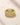 A stack of three ENVYONE 18K Gold Plated eternity rings featuring clear pavé and round-cut zircon stones on a textured beige stone surface.