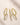 Three ENVYONE 18K Gold Plated eternity rings featuring brilliant white zircon stones and intricate detailing on a beige stone surface.
