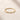 Closeup of an ENVYONE 18K Gold Plated 925 Sterling Silver ring with brilliant white zircon stones displayed on a natural stone surface.