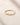 Closeup of an ENVYONE 18K Gold Plated 925 Sterling Silver ring with brilliant white zircon stones displayed on a natural stone surface.
