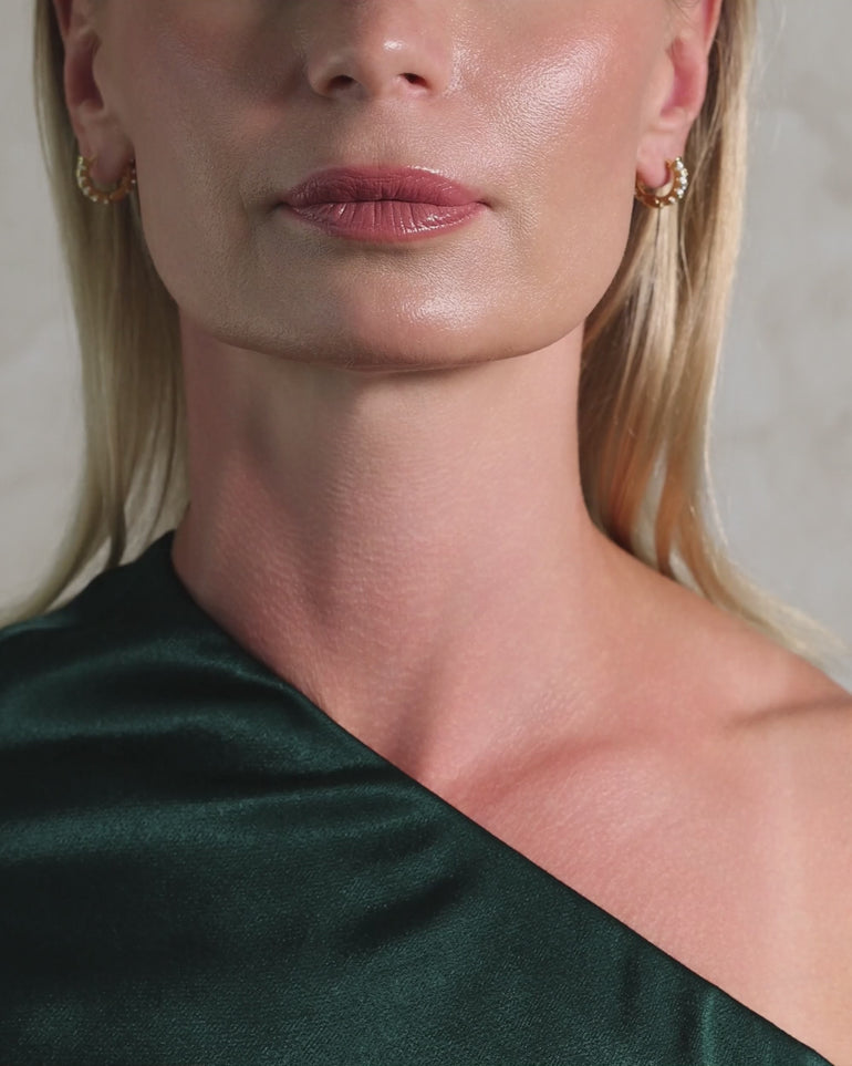 Video of a woman wearing ENVYONE 18K Gold Plated hoop earrings featuring embossed sparkling zircon stones.