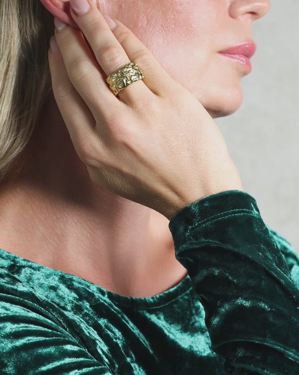 Video of Woman showcasing an ENVYONE 18K Gold Plated stainless steel wide-band ring with raised detailing and crystal accent.