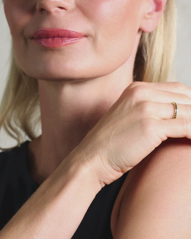Close-up video of a woman wearing an ENVYONE 18K Gold Plated black zircon eternity ring.
