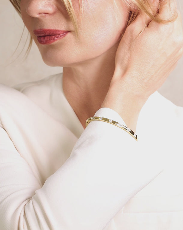 Detailed video of an ENVYONE 18K Gold-Plated zircon bangle styled on a woman's wrist.