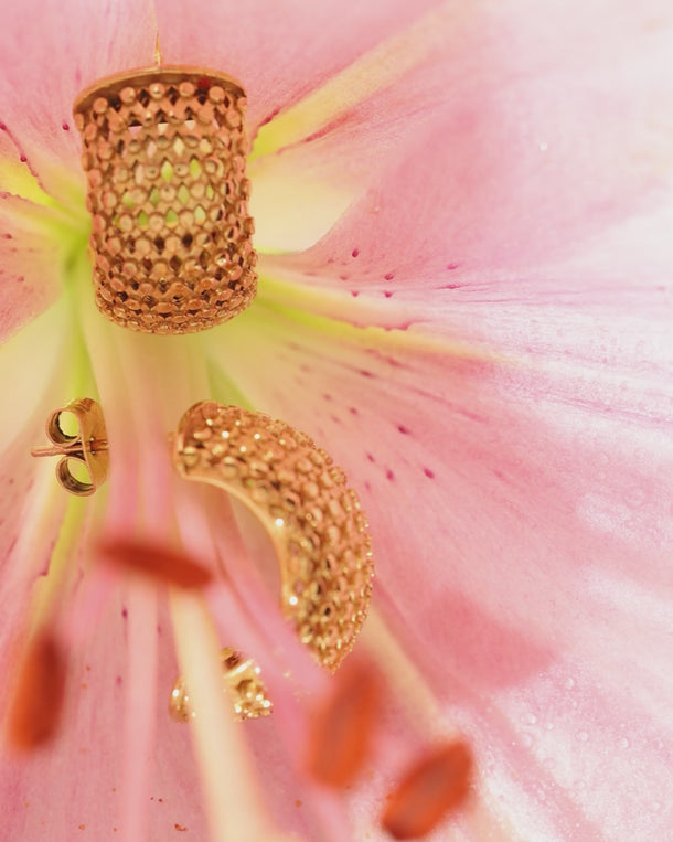 Video of ENVYONE 18K Gold Plated textured hoop earrings displayed with a pink lily flower