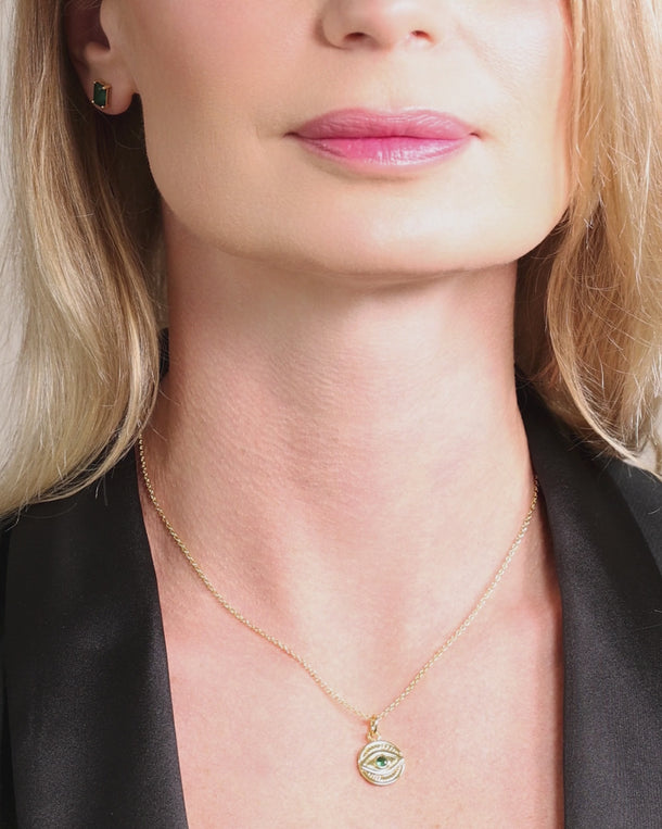 Video of a woman wearing an ENVYONE 18K Gold Plated evil eye pendant necklace with a dark green cubic zirconia stone.
