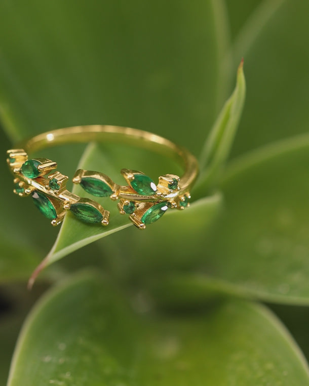 ENVYONE 18K Gold Plated 925 Sterling Silver green zircon ring showcased among lush green leaves in a closeup jewellery video.