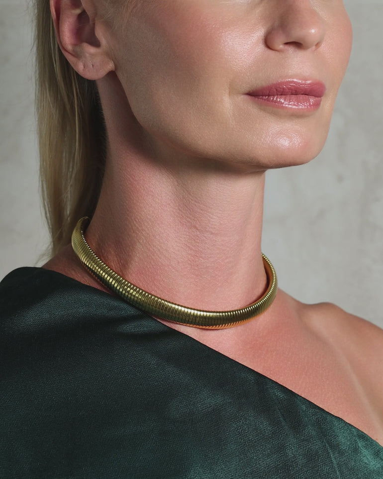 Closeup video of a woman wearing an ENVYONE 18K Gold Plated statement collar necklace styled with a one-shoulder top.