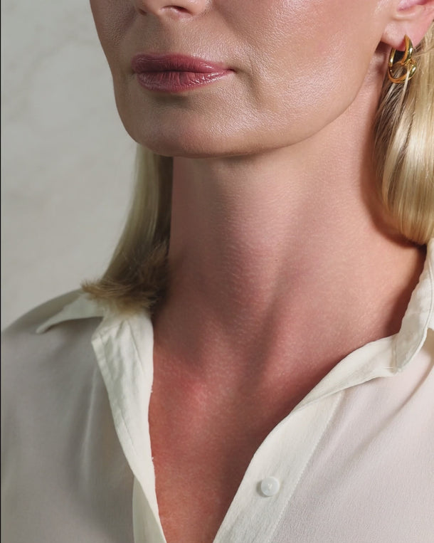 Video of a woman wearing ENVYONE 18K Gold Plated premium stainless steel hoop earrings with a sculptural spiral design.